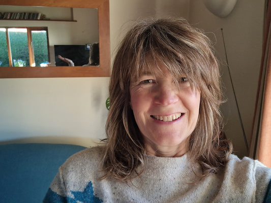 Head and shoulder shot of Jo smiling at the camera with a new shoulder-length, feathered and layered haircut