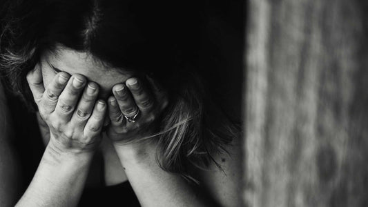 despairing woman with her face in her hands