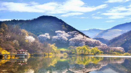 beautiful blue sky with white clouds above stunning mountain scenery behind a clear lake