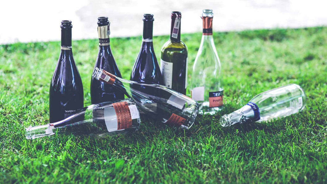 empty bottles of wine on a grassy lawn