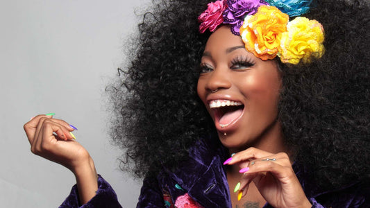 woman smiling confidently at the camera with bright flowers in her hair to represent sober confidence