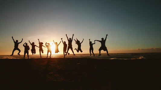 silhouette of sober people jumping for joy in front of sunset to represent freedom and confidence