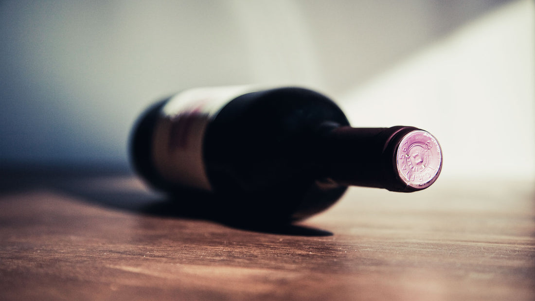bottle of red wine lying on its side on a wooden table